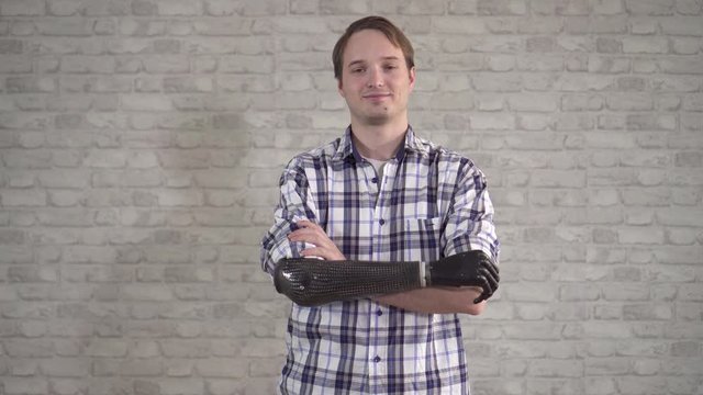Portrait of a positive young man with a bionic prosthetic arm