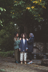 Three stylish young women in fashion clothes.