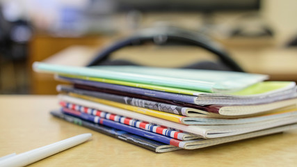 image of a stack of notebooks on the teacher's desk