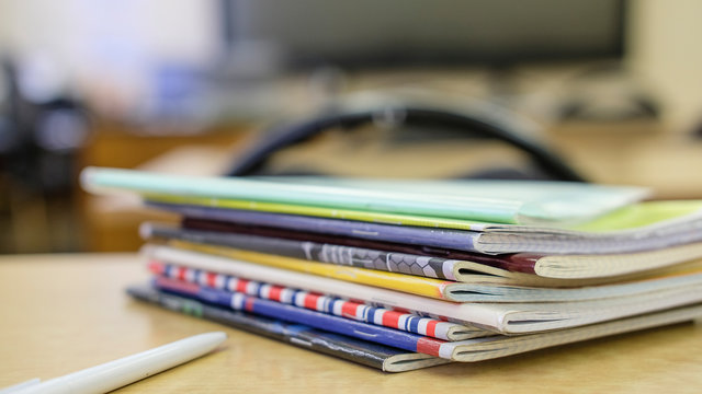 image of a stack of notebooks on the teacher's desk