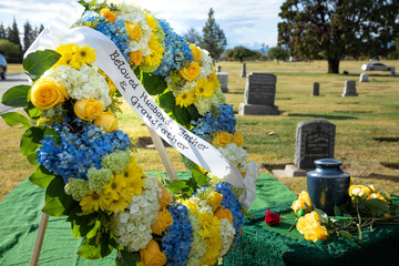 Flower wreath beside a burial urn at a funeral