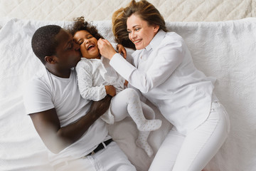 Family laying down together in a bed