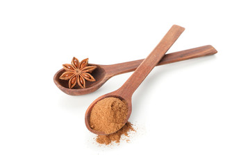 Wooden spoons with cinnamon powder and anise isolated on white background