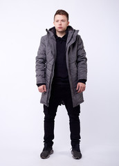 A man stand up wearing gray jacket isolated white at the studio.