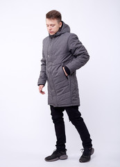 Fototapeta premium A man stand up wearing gray jacket isolated white at the studio.