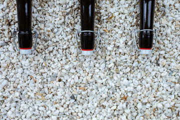 Close up black bottles for wine storage, isolated on white stones.
