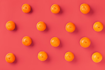 Fototapeta na wymiar Fruit pattern of fresh orange tangerine or mandarin over living coral background. Flat lay, top view. Pop art design, creative summer concept. Citrus in minimal style..