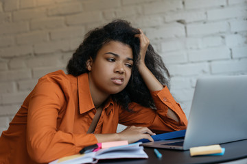 Portrait of exhausted business woman using laptop, multitasking, hard working in office. Sad freelancer missed deadline.Tired and stressed student studying, learning language, examination