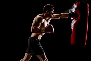 Boxer punching a bag with dust particles coming out