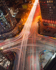 Aerial view of Winnipeg's iconic intersection, Portage and Main at night, with light trails of vehicles passing by