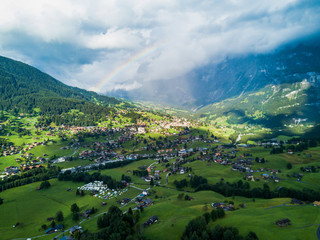 Fototapeta na wymiar Sun shines over Swiss village Grindelwald after heavy storm in summer time near Swiss Alps
