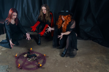 stories for halloween three beautiful young witches over a burning pentagram