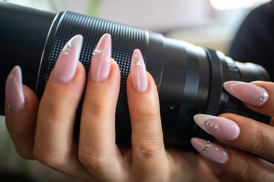 Old vintage manual photo lens in women's hands with manicured nails