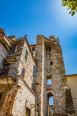 Fototapeta na wymiar A characteristic glimpse in the ancient medieval village of Narni. Umbria, Terni, Italy. Old stone and brick buildings.The blue sky on a summer day. A bell tower. Empty windows.