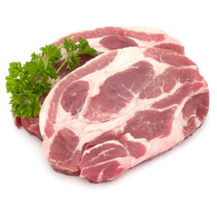Raw pork neck chop meat with parsley herb leaves garnish isolated on white background cutout