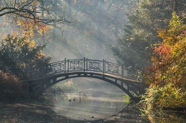 Beautiful autumn colorful landscape. Bridge in the city park in Pszczyna, Poland.