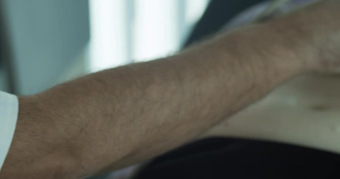 Doctor internist using ultrasound machine during medical examination of older female patient in the office room.