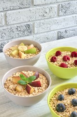 Sweet delicious healthy breakfast. Different porridge with fruit on a wooden kitchen table.