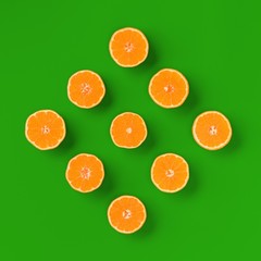 Fruit pattern of fresh orange tangerine or mandarin on green background. Flat lay, top view. Pop art design, creative summer concept. Citrus in minimal style.
