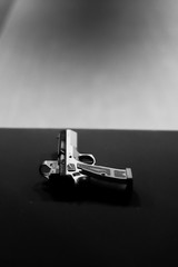 monochrome gun sitting on shooting range table