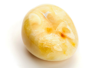 Natural amber. A piece of yellow opaque natural amber on white background.