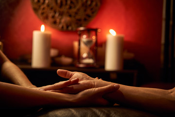 Obraz na płótnie Canvas A woman does acupressure fingers for a man. hand massage with intimate lighting. Prelude before making love. Close. Complete relaxation