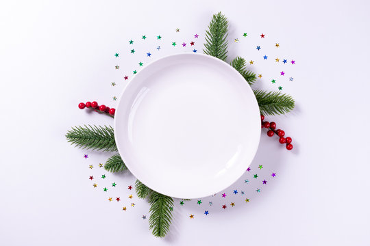 Empty Plate Dish With Space For Text And Two Decorative Fir Branches On White Background. New Year Or Christmas Concept.