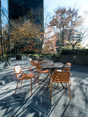 Obraz premium Orange patio chair and table set outside in a busy downtown area in Bellevue, Washington.
