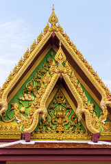 Fototapeta premium Ko Samui Island, Thailand - March 18, 2019: Wat Laem Suwannaram Chinese Buddhist Temple. Golden gable with Guan Yin statue against light blue sky.