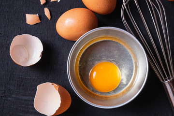  Yolks and egg protein in a cup. Corolla whisk eggs. Preparation of food and chicken eggs