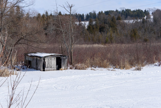 Abandoned boathouse on frozen river in winter
