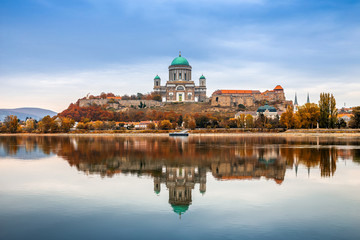 Fototapeta na wymiar Esztergom, Hungary - Beautiful autumn morning with the Basilica of the Blessed Virgin Mary at Esztergom by the River Danube. Autumn colors and reflections of the Basilica are mirrored in water