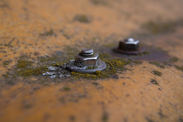 Close-up photography of a nut and bolt on a rusty background