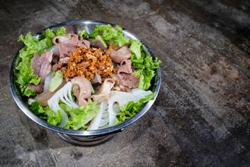 Thai style meat soup in a hotpot with vegetable on wood background