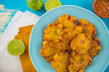 Food photography of latin american tostones or patacones on a blue background