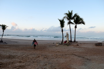 Deserted beach with a surfer coming