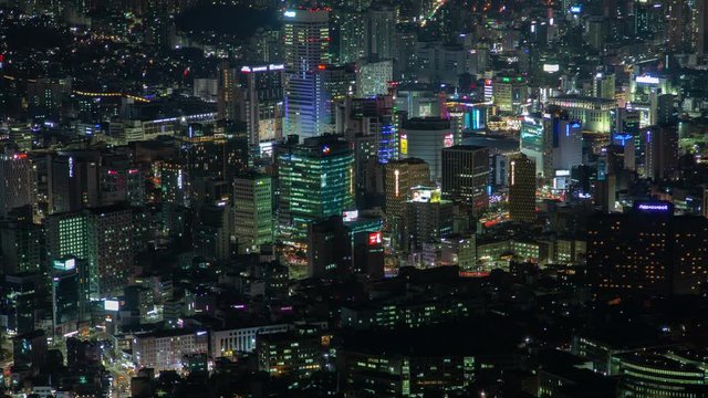 Timelapse fantastic Seoul flashing illumination of various colours on modern buildings and skyscrapers at night pan up
