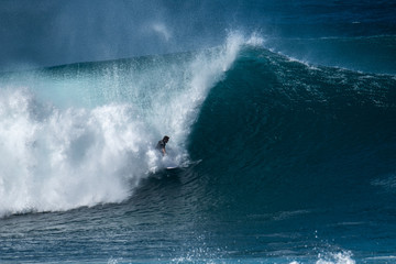 Surfer rides huge wave at the famous Banzai Pipeline surf spot located on the North Shore of Oahu in Hawaii
