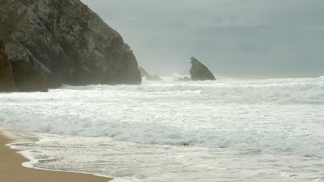 Wild Atlantic ocean coast at Adraga Beach in Portugal - travel photography