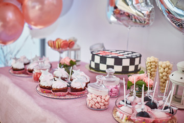 beautiful pink candy bar with cupcakes, pops, cake.