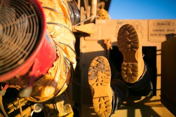 Rope access miner wearing safety boot harness, helmet entering into confined space manhole door construction mine site Perth, Australia 