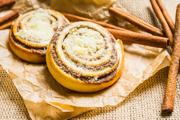 Fresh cinnamon buns on the rustic wooden background. Selective focus. Shallow depth of field.