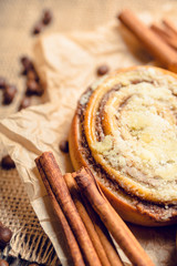 Fresh cinnamon buns on the rustic wooden background. Selective focus. Shallow depth of field.