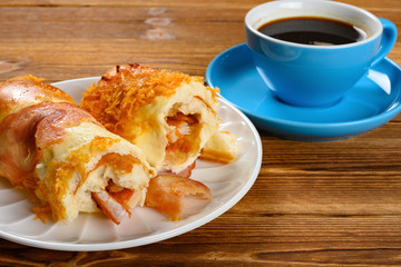 side view cut out bread with bacon and shredded pork and cup of coffee horizontal composition