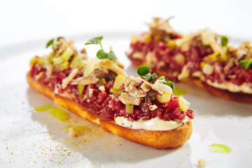 Beef Tartare on Toast with Black Garlic Cream Isolated