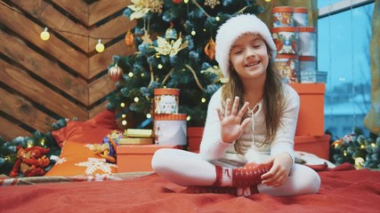 4k video of young female wearing christmas hat waving hand, invitingeveryone to celebrate with her on wooden background. - Powered by Adobe