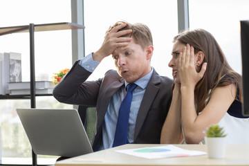 Boss and co-worker looking at notebook screen..