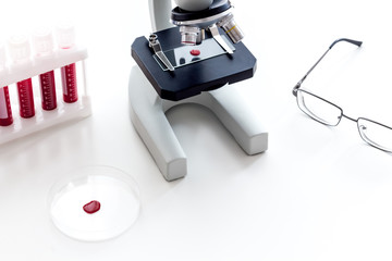 Blood testing laboratory. Samples viewing under microscope near tubes on white background top view space for text
