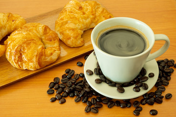 Hot Americano Black Coffee with Croissant on The Wooden Table
