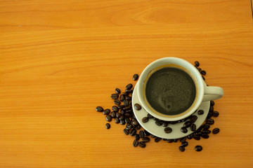 Top View of Hot Americano Black Coffee and Coffee Bean on The Wooden Table